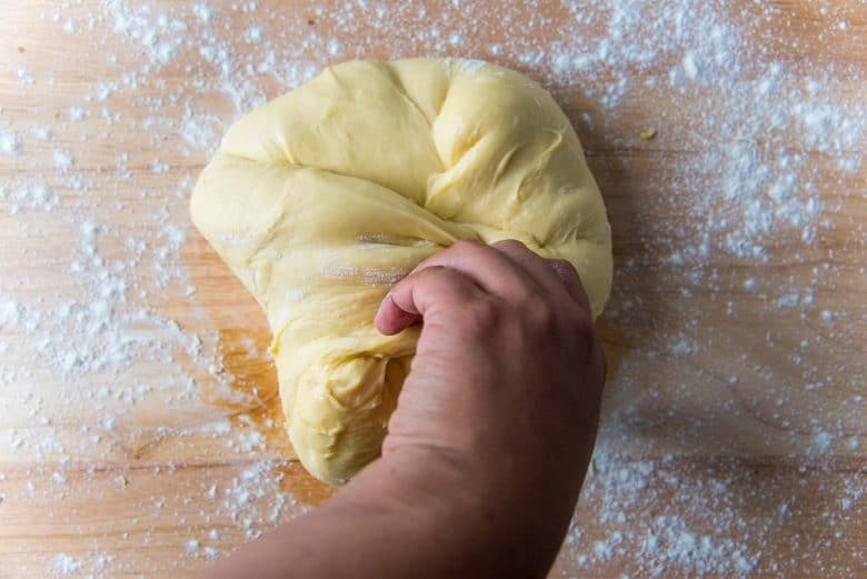 Folding the brioche dough by hand towards the middle.