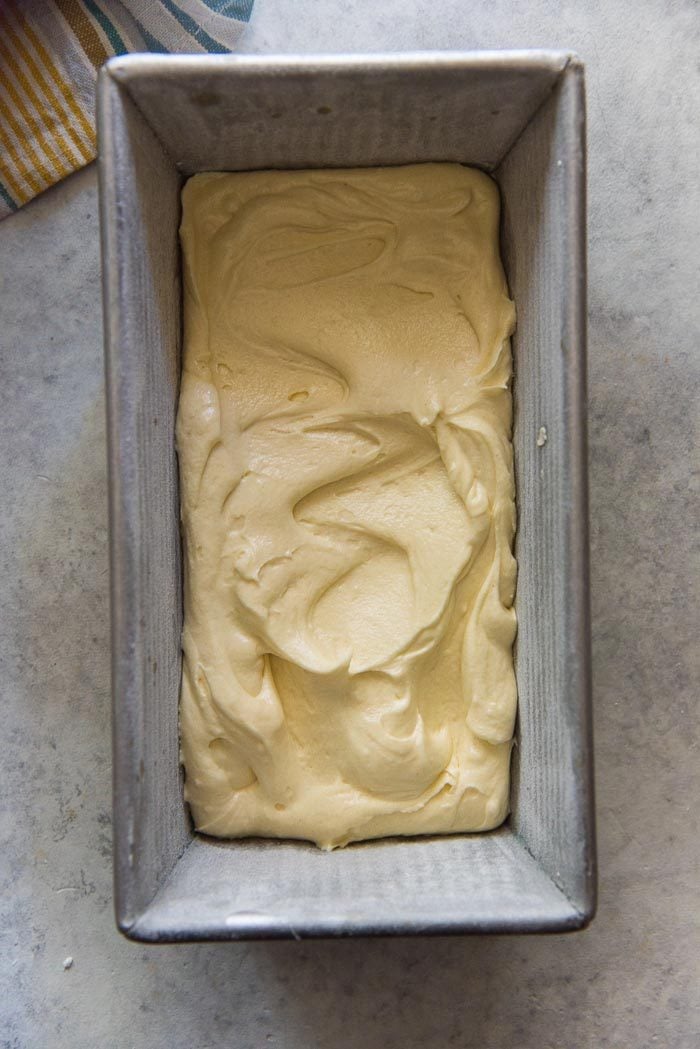 The pan with the first layer of cake batter spread out, making sure to reach the corners.