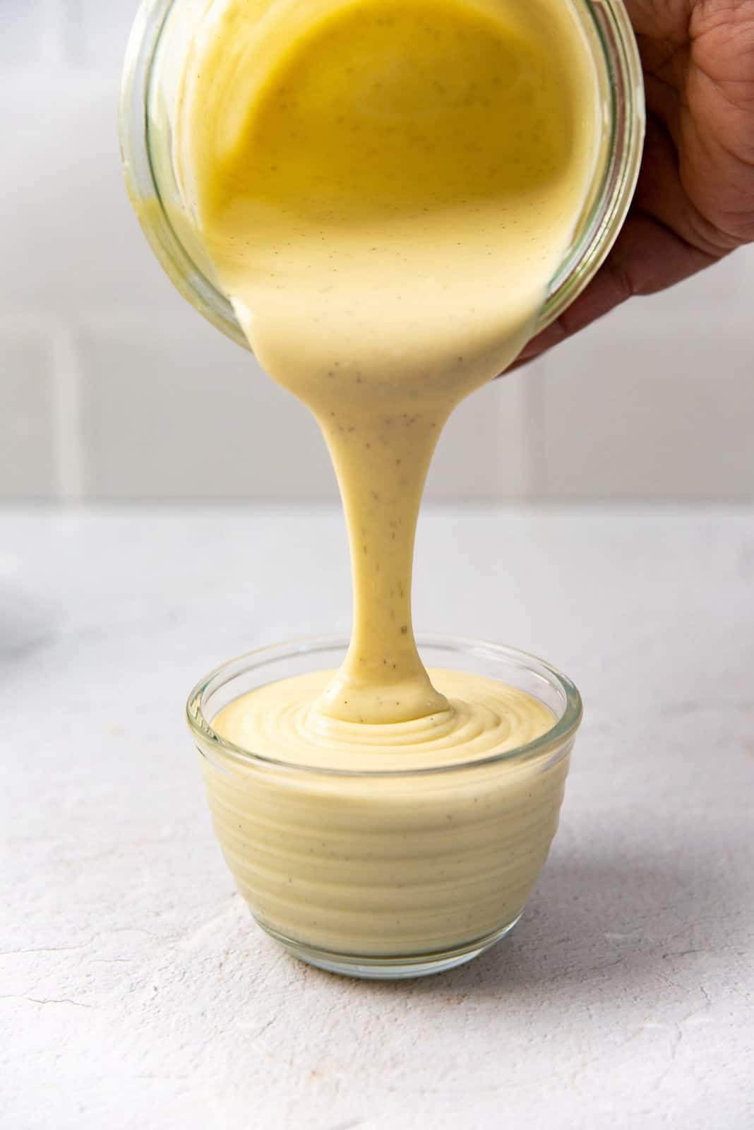 Pouring custard being poured into a small bowl to show the consistency.