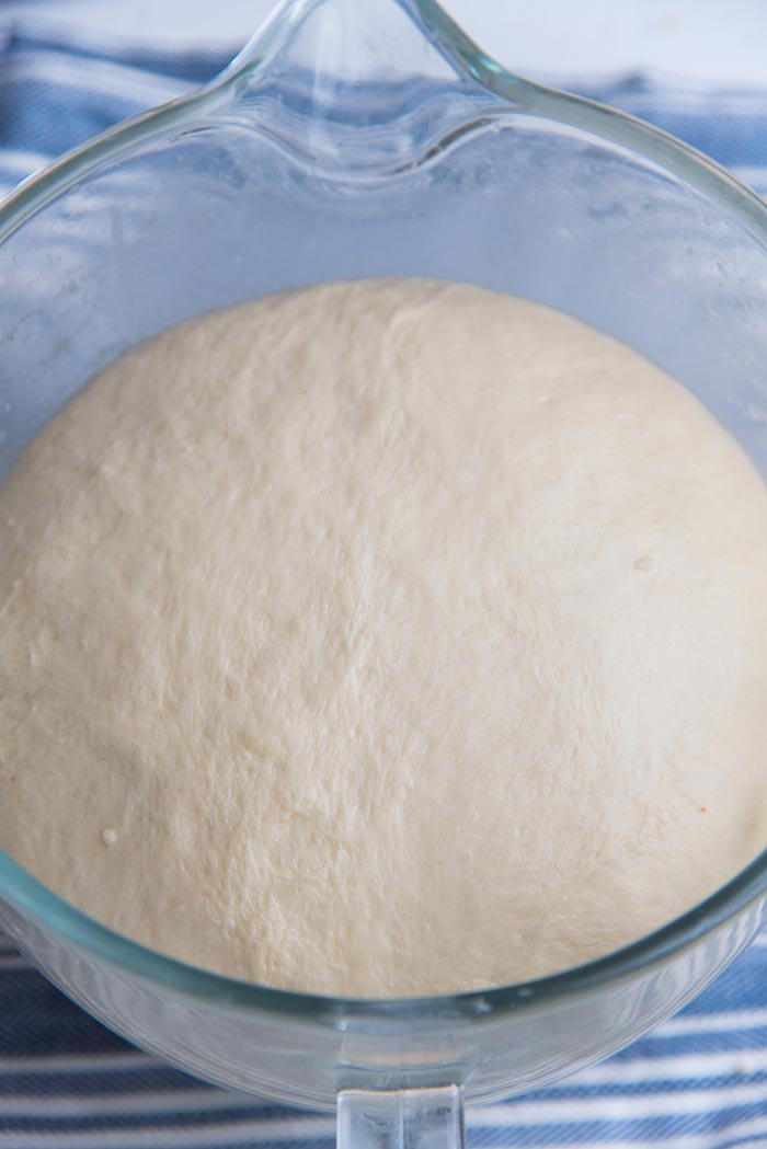 The bread dough in the mixer bowl, doubled in size after being proofed.