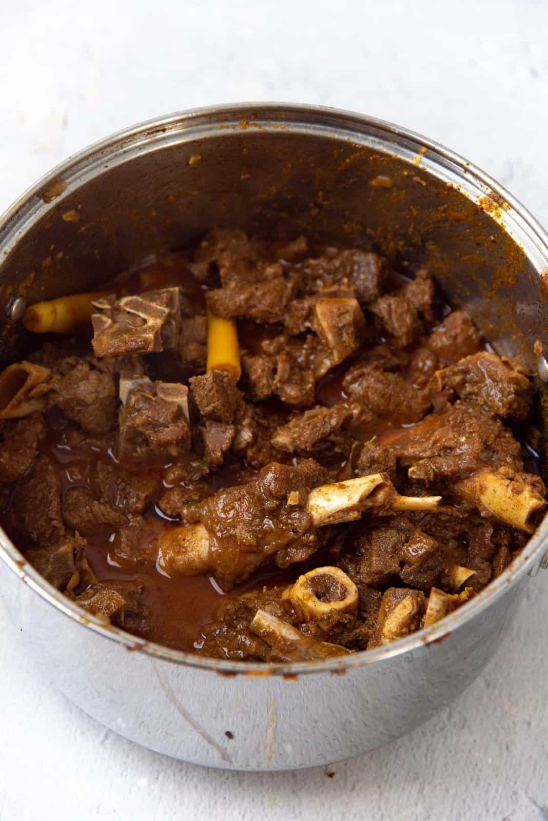 A close up of the mutton curry cooked in a pot.