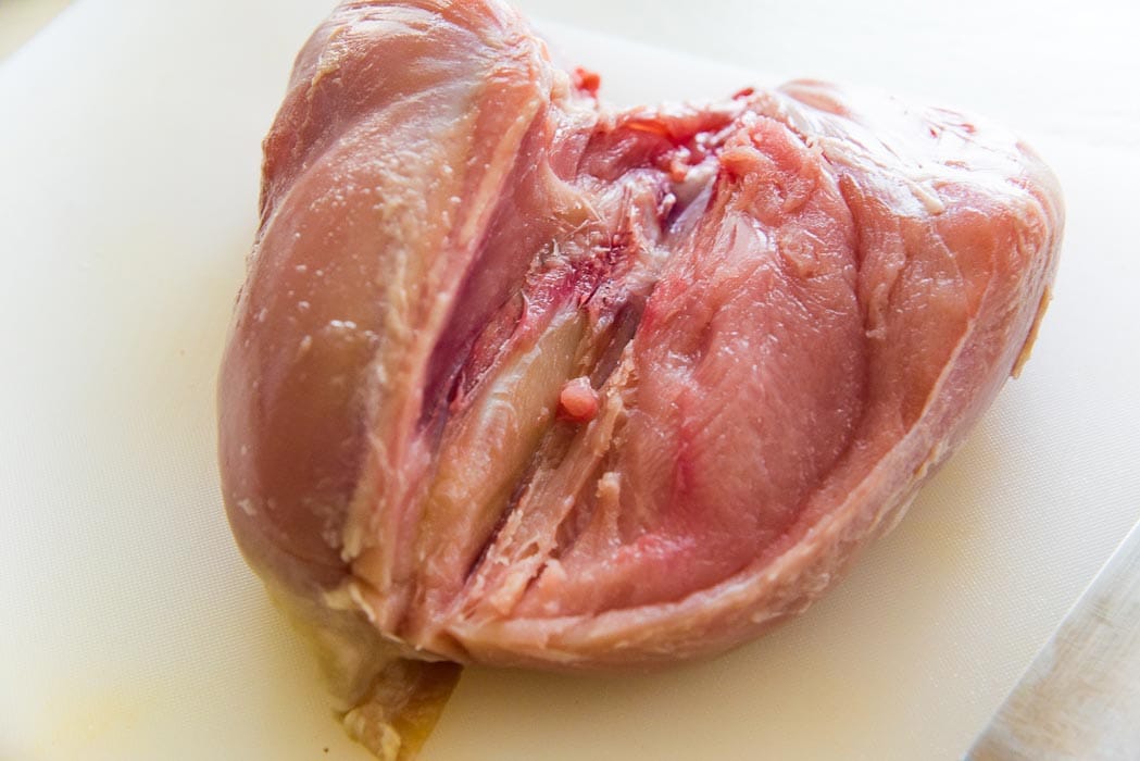 The turkey breast is almost filleted off the turkey breast bone.