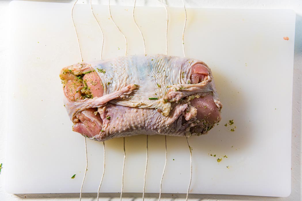 Place cotton twine at 1 inch intervals underneath the turkey roulade.