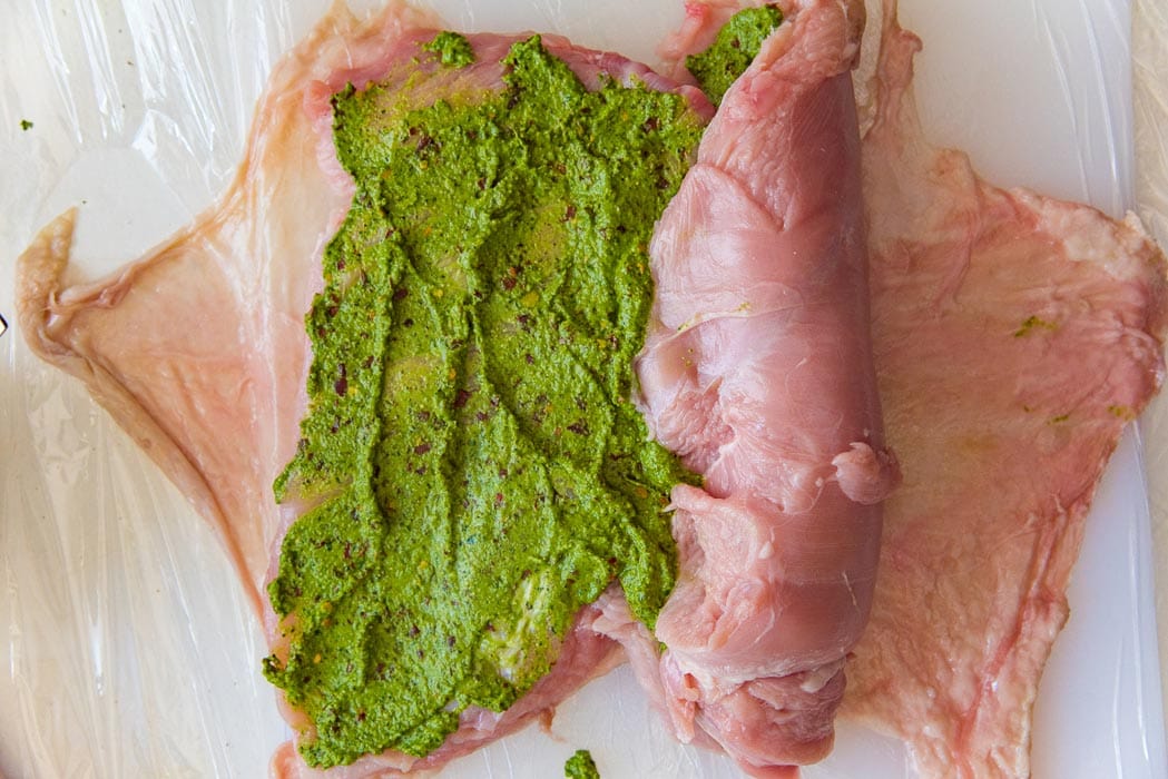 Start rolling up the meat as tightly as possible to make the roulade.
